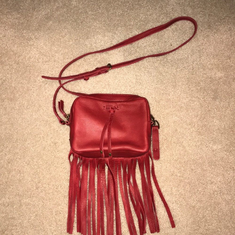 Red leather, cross body purse with fringe bottom.